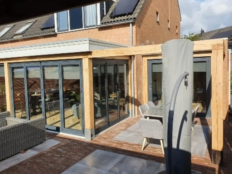 Aanbouw met houten kozijnen en een glazen pui aan een rijtjeswoning