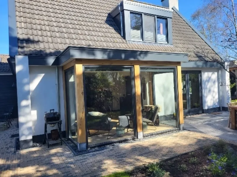 Aanbouw met grote ramen aan een twee-onder-een-kapwoning