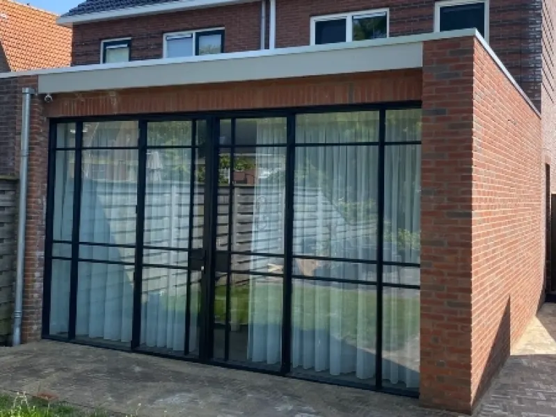 Gemetselde aanbouw met een stalen pui